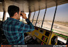 یکی از کارکنان برج مراقبت فرودگاه مهرآباد در حال رصد هواپیماهای در حال فرود و پرواز 